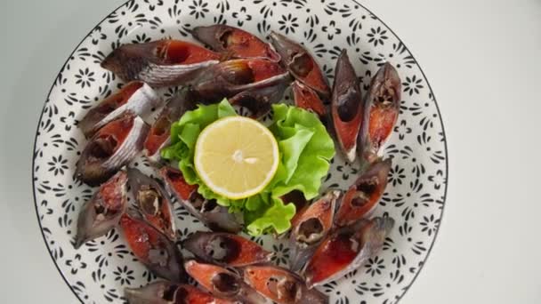Mariscos, trozos jugosos salados de pescado con caviar con lechuga y limón en un plato blanco, primer plano — Vídeo de stock