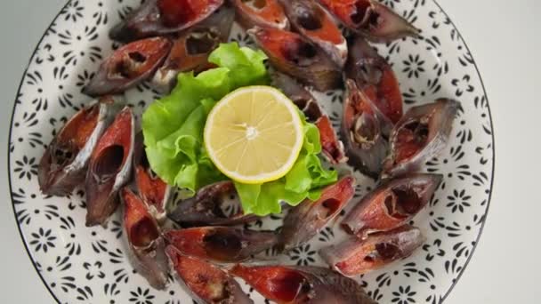 해산물 접시, 맛있고 얇게 썬 생선, 접시 위에 캐 비어 와 상추와 레몬이 곁들여진 하얀 식탁보, 클로즈업 — 비디오