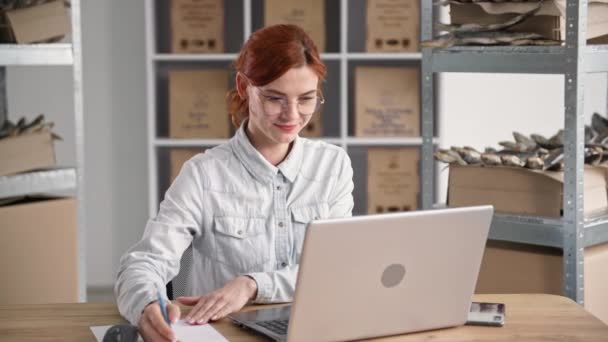 Young businesswoman small business owner, works online and takes orders in internet shop while sitting in fish warehouse — Stock Video