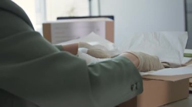 Online giyim mağazasının müşterilerine mal teslimatı, kadın eli eldivenli, yakın plan.