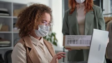 Bırakma, tıbbi maskeli genç bayan girişimci ve bir meslektaşı bir perakende internet mağazasında siparişlerin teslim edilmesini resmileştirdiler.