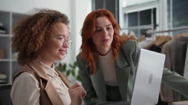 Moda butiği, Depoda otururken dizüstü bilgisayar kullanan müşteriler için Ojelda online mağazasında siparişleri düzenleyen genç kadınlar.