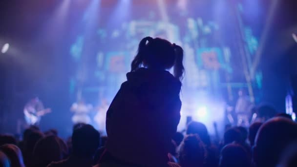 Concert de nuit avec de la fumée sur scène au ralenti, fan gamine sur les épaules du père profiter artiste écoute — Video