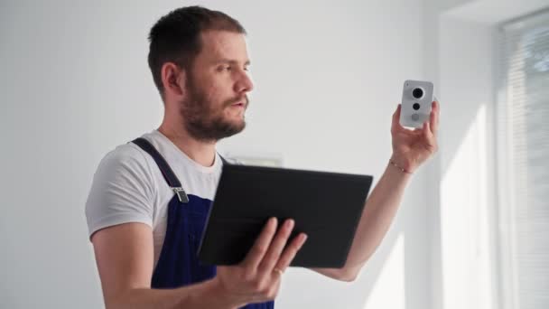 Retrato do homem verificando o trabalho da câmera de vigilância sem fio e aplicação em tablet digital, sorrindo e olhando para a câmera — Vídeo de Stock