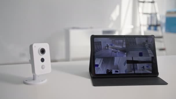 Tecnologías inalámbricas, cámaras de vídeo modernas se encuentra junto a la tableta digital y muestra una imagen de la habitación mediante la aplicación, primer plano — Vídeos de Stock