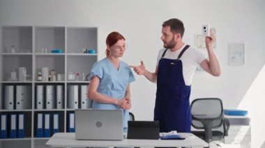 Özel güvenlik için güvenlik kamerası, neşeli adam genç bayana gizli güvenlik kamerasını ve laptop ve dijital tablet uygulamasını anlatıyor, gülümsüyor ve kameraya bakıyor.