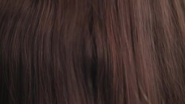 Cura dei capelli, pettine si muove lungo bei capelli castani fluenti lunghi sani da vicino, consistenza — Video Stock