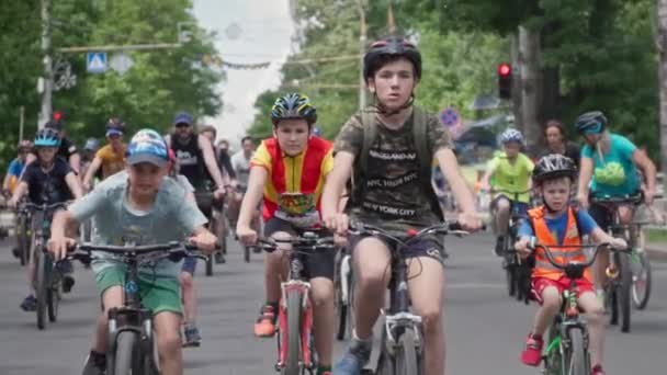 Kherson, Ukraine August 10, 2021: crowd of joyful male and female children in sportswear and helmets on bicycles ride on city road on summer day — Stock Video