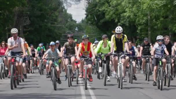 Kherson, Oekraïne 10 augustus 2021: Fietsfestival, groep mensen in sportkleding in helmen op fietsen rijden langs de weg in de stad op zonnige dag — Stockvideo