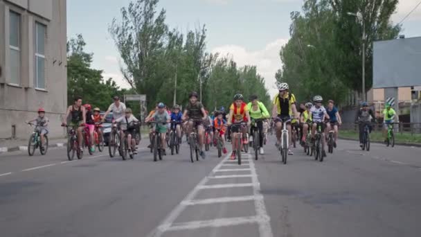 Kherson, Ucrania 10 de agosto de 2021: multitud de adolescentes y adolescentes llevan un estilo de vida activo y participan en paseos en bicicleta por las calles de la ciudad — Vídeo de stock