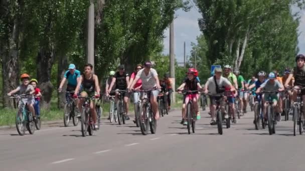 Kherson, Ukraina Augusti 10, 2021: kittlande barn, många barn man och kvinna i hjälmar och sportkläder rida cykel på vägar i staden — Stockvideo