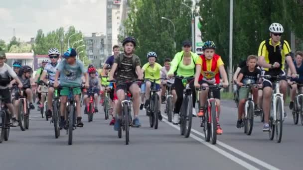 Херсон, Украина 10 августа 2021 года: занятия для детей, подростки женского и мужского пола в спортивной форме на велосипедах едут по дороге в город в летний день — стоковое видео