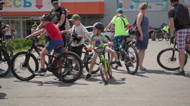 Херсон, Україна 10 серпня 2021 року: діти чоловічої статі разом зі своїми татами у спортивній формі та шоломах на велосипедах їдуть містом. — стокове відео