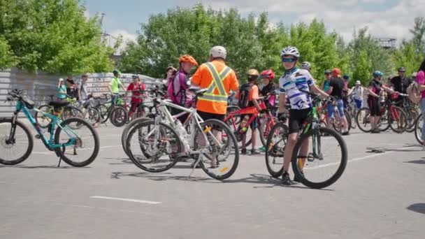Kherson, Ukraina Augusti 10, 2021: folkmassa tillsammans med barn i sportkläder och hjälmar med cykel förbereder sig för cykeltur runt staden — Stockvideo