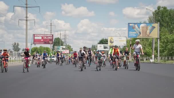 Kherson, Ucrania 10 de agosto de 2021: niños y niñas activos en ropa deportiva que usan una bicicleta de paseo en el casco en la carretera en un día soleado caliente durante el viaje a la ciudad en transporte ecológico — Vídeos de Stock