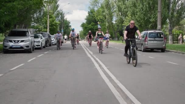 Kherson,ウクライナ2021年8月10日:スポーツ趣味,自転車に乗っている間、道路に沿ってヘルメットに乗る自転車を身に着けている若い男性と女性の群衆 — ストック動画