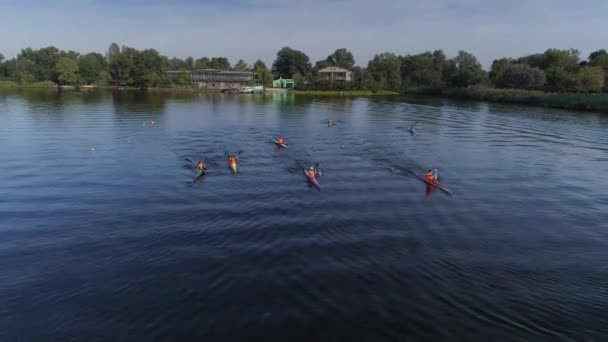 KHERSON, UCRANIA - 20 de septiembre de 2021, deportes acuáticos, niños atletas con chalecos salvavidas se sientan en barcos y remos en el fondo del río de rayos solares, aéreos — Vídeo de stock