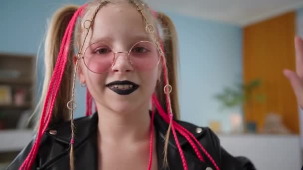 Gyermek vegye el a kezét a kamerából, és pózol, divatos kislány fekete ajkakkal és rózsaszín copfokkal tartja chihuahua kutya és mutatja hüvelykujját fel — Stock videók