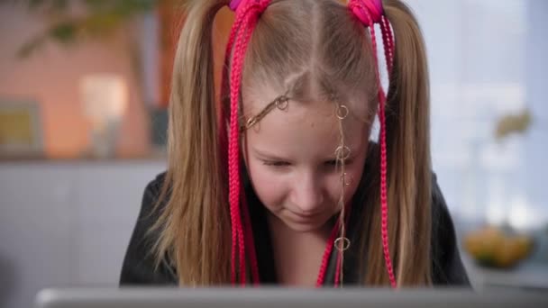 비디오 게임을 배우는 거리에 의존하는 10 대, 분홍색 꼬리를 가진 행복 한 소녀는 노트북을 사용 한다 — 비디오