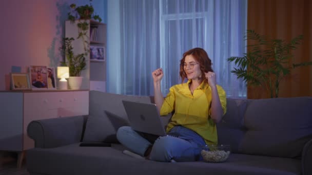 Chica emocional se emociona viendo la lotería o el partido de deportes y reacciona felizmente a las buenas noticias en Internet o ganará fácilmente — Vídeo de stock