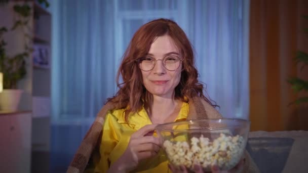 Lány eszik popcorn és néz vicces műsor a TV-ben este szabadidő otthon — Stock videók