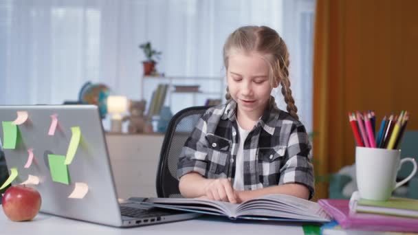 Dívka dělá domácí úkol a čtení knihy s domácím úkolem v pokoji — Stock video