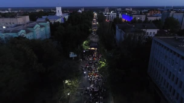 KHERSON, UKRAINE - 7 septembre 2021 Festival Melpomene de Tavria, défilé festif avec une foule heureuse de personnes avec des ballons marchant le long de la rue du soir de la ville, aérien — Video