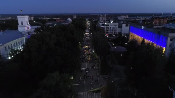 KHERSON, UKRAINE - 7 septembre 2021 Festival Melpomene de Tavria, parade nocturne avec foule de personnes marchant dans la rue le soir pendant les vacances, aérien — Video