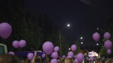 KHERSON, UKRAINE - 7 Eylül 2021 Tavria Melpomene Festivali, ellerinde mor balonlarla yol boyunca yürüyen neşeli insan kalabalığı