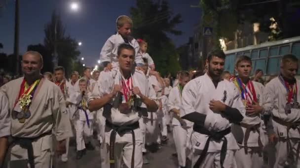 KHERSON, UKRAINE - 7 septembre 2021 Festival Melpomene de Tavria, groupe de célibataires en kimono marchent le long de la rue de nuit pendant le défilé festif en ville — Video