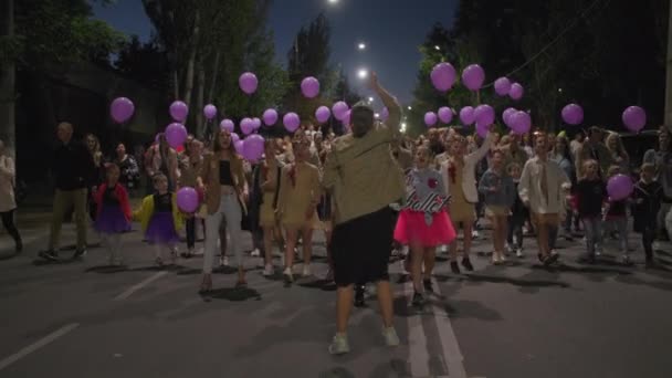 KHERSON, UKRAINE - 7 Eylül 2021 Tavria Melpomene Festivali, ellerinde mor balonlarla neşeli kadın kalabalığı geçit töreninde mutlu bir şekilde yürür ve motivasyon sloganını ortaya çıkarır. — Stok video