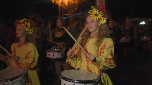 KHERSON, UCRANIA - 7 de septiembre de 2021 Festival Melpomene of Tavria, linda chica disfrazada toca palos de tambor en un instrumento musical durante el desfile nocturno en la ciudad el día festivo — Vídeo de stock