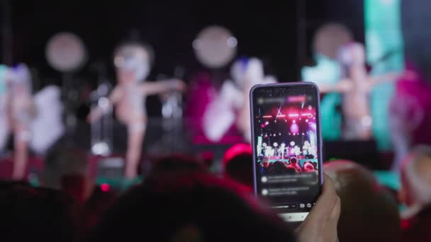 KHERSON, UKRAINE - szeptember 7, 2021 Festival Melpomene of Tavria, woman is broadcasting live on a smartphone during a festive concert at a festival, close-up — Stock videók