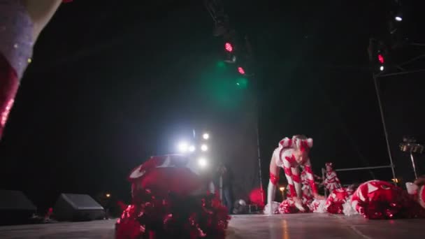 KHERSON, UKRAJINA - 7. září 2021 Festival Melpomene z Tavrie, okouzlující mladé tanečnice v kostýmech držící v rukou bambuli, předvádějí akrobatické kousky během pozdního večerního jelena — Stock video