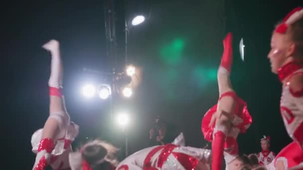 KHERSON, UKRAINE - 7 września 2021 Festiwal Melpomene w Tavrii, pokaz baletu żeńskiego w kostiumach cheerleaderek wykonuje akrobatyczne akrobacje podczas miejskiego koncertu późną nocą — Wideo stockowe