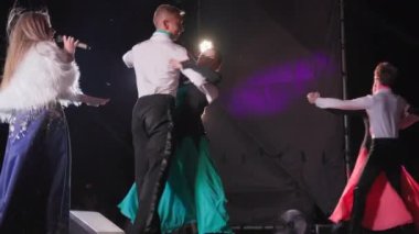 KHERSON, UKRAINE - 7 Eylül 2021 Tavria Melpomene Festivali, erkek ve kadın dansçıların sevimli çiftleri akşamın geç saatlerinde sahne ışıkları altında dans ediyorlar.