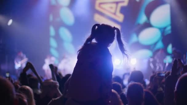 KHERSON, UCRAINA-SETTEMBRE 7, 2021: Festival Melpomene di Tavria, bambina con code di cavallo che salta insieme al padre sulle spalle durante il concerto notturno, folla di persone che applaudono — Video Stock