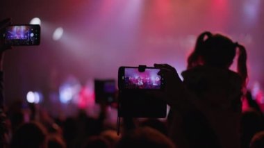 KHERSON, UKRAINE-SEPTEMBER 7, 2021: Tavria Melpomene Festivali, renkli spot ışıklarıyla sahnedeki cep telefonu sanatçılarını çeken bir kalabalık, açık hava konserlerinde çok sayıda taraftar