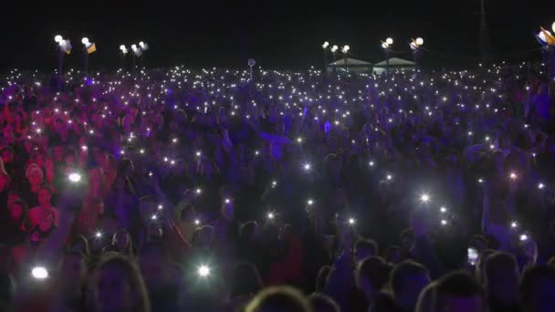 KHERSON, UKRAINE-WRZESIEŃ 7, 2021: Festiwal Melpomene w Tavrii, rozrywka, tłum ludzi machających rękami światłami telefonów komórkowych podczas koncertu muzyki na żywo w nocy — Wideo stockowe