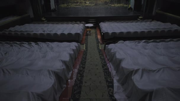 Cámara se mueve en las escaleras con alfombra entre filas de asientos vacíos, escenario en blanco con cuerdas decorativas en un antiguo teatro — Vídeos de Stock