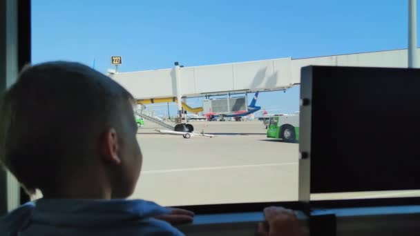 ANTALYA, TURQUÍA - 21 DE JULIO DE 2021: niño lindo mira por la ventana al conducir a través del aeropuerto, niño pequeño en el autobús de traslado de pasajeros — Vídeo de stock
