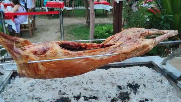 KEMER, TURQUIA - JULHO 22, 2021: carneiro é frito no cuspo em uma fogueira aberta em um restaurante, comida turca nacional no festival de comida — Vídeo de Stock