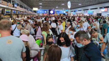 ANTALYA, TURKEY - 31 Temmuz 2021: Maskeli kalabalık salgın sırasında havaalanında pasaport kontrolü için sırada bekliyor