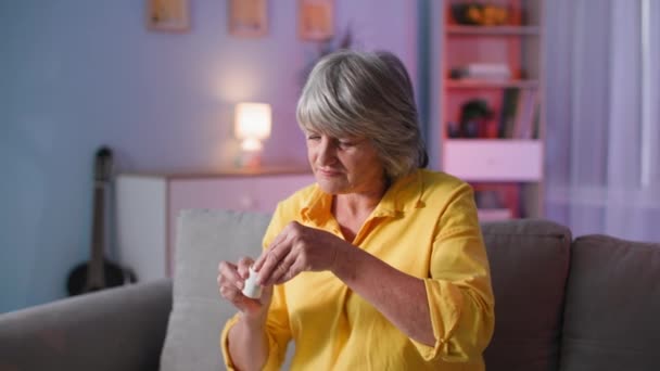 Vecchia vita umana e sana di qualità, ritratto di età 60 anni signora prende capsula medicina con acqua e guardare sulla macchina fotografica — Video Stock