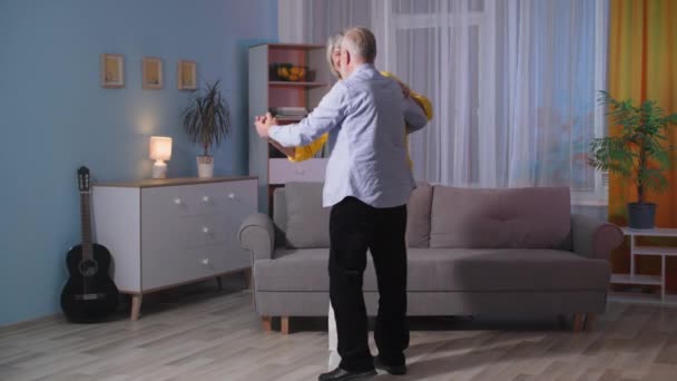 Boldog idős pár szerelmes tánc a szobában, idős szép férj és feleség romantikus este otthon — Stock videók