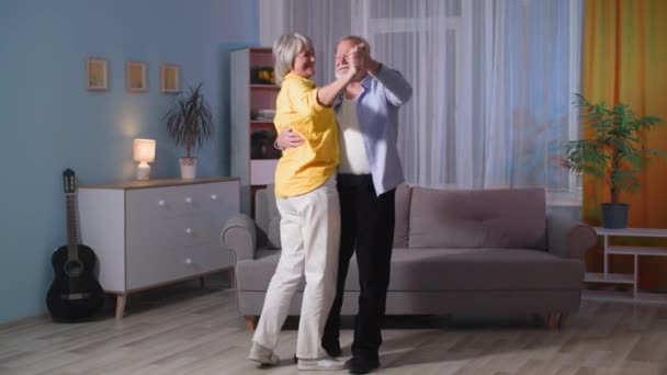 Feliz despreocupado ancianos abuelos mayores bailando en la habitación, amante viejo marido riendo sosteniendo esposa madura, pareja divirtiéndose en casa — Vídeos de Stock