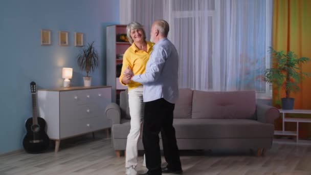 Couple enjoy life together on retirement feels happy healthy, two elderly people in love dancing in room — Stock Video