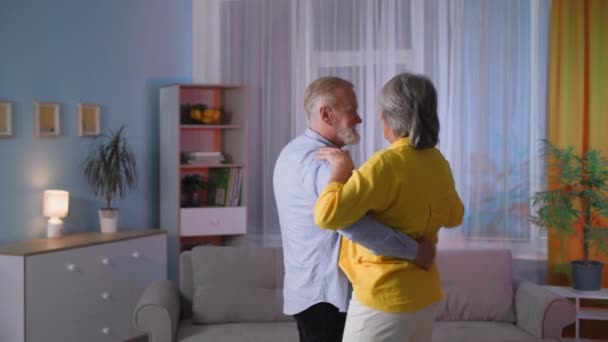 Feliz casal de cabelos grisalhos idosos dançando em casa à noite, bela família aposentada passar tempo juntos — Vídeo de Stock