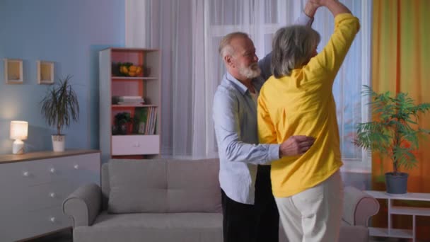 Romantic elderly couple dancing at home in evening, retired grandparents spend time together — Vídeo de Stock