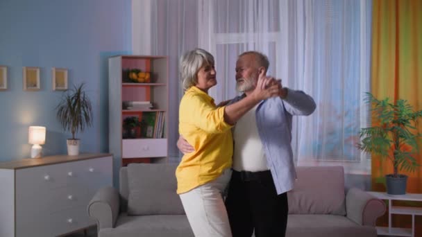 Portrait of dancing elderly couple, loving husband having fun with his wife at home, grandparents enjoy life together — Video Stock